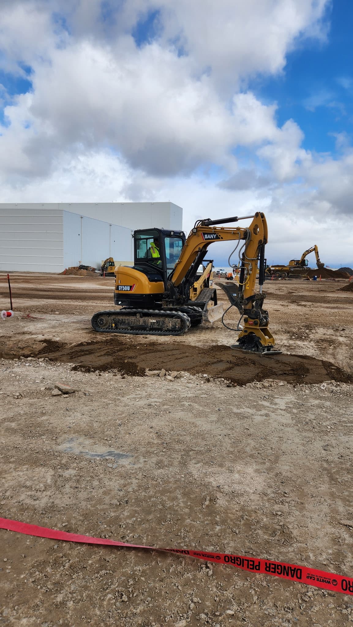 SANY mini excavator with compaction attachment on a commercial utility line installation site
